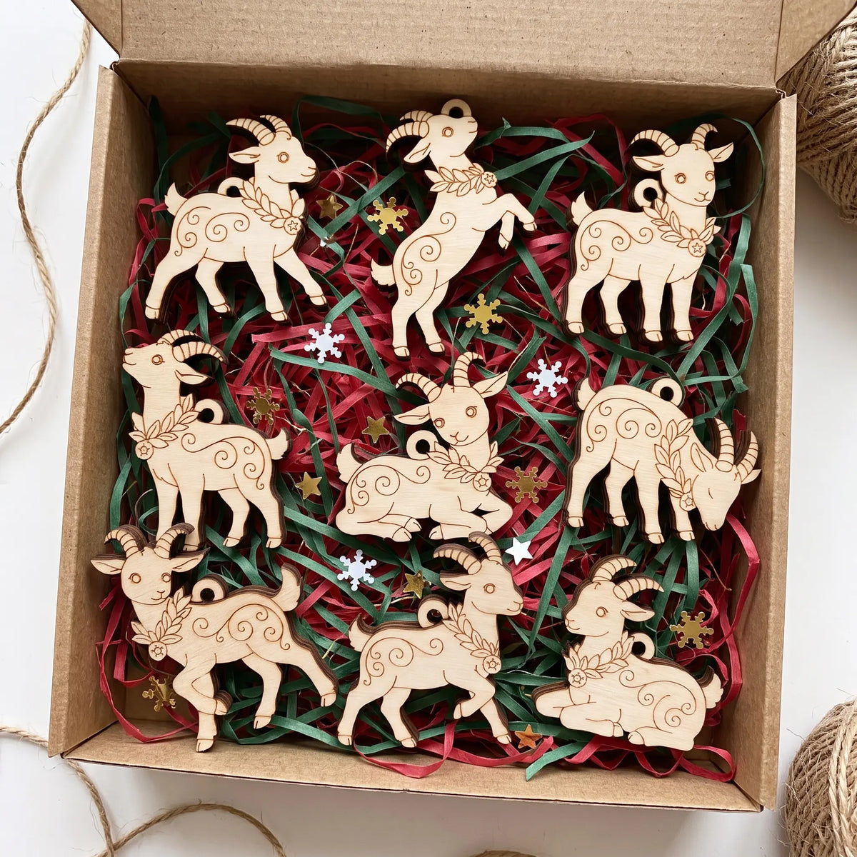 Craft gift box filled with paper filler and complete set of laser cut plywood goat ornaments with engraved patterns.