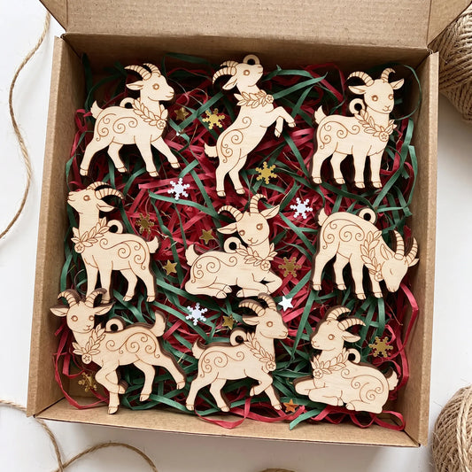 Craft gift box filled with paper filler and complete set of laser cut plywood goat ornaments with engraved patterns.
