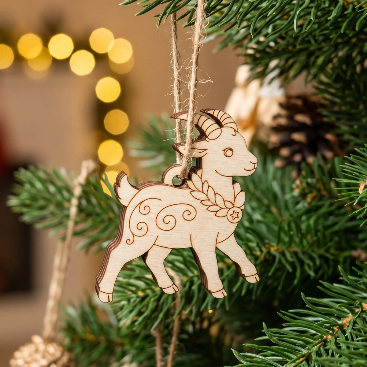 Laser cut plywood walking goat ornament with engraved patterns hanging on a natural Christmas tree with holiday lights.