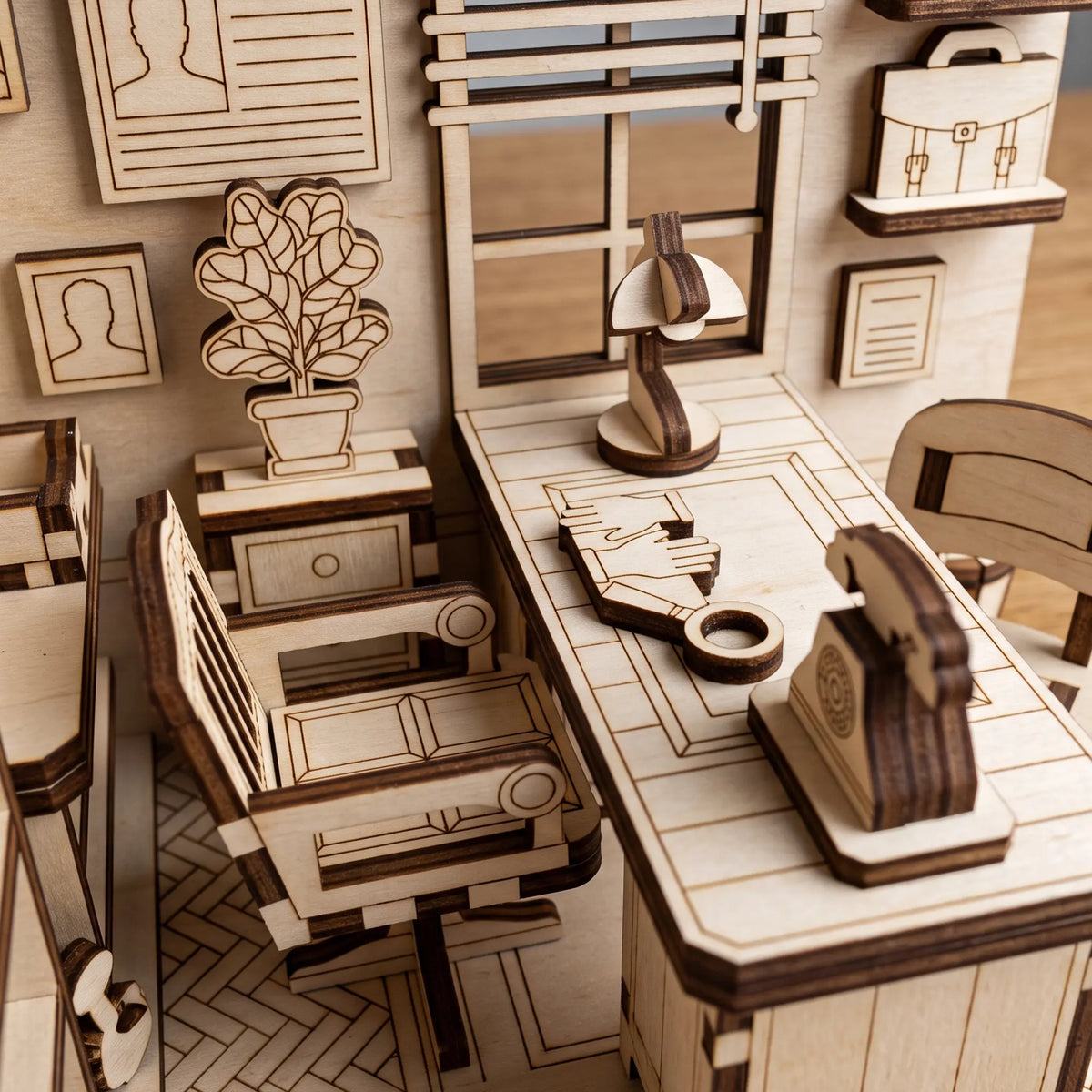 Close-up of laser cut plywood detective office book nook highlighting miniature desk, rotary phone, lamp, and office chair.