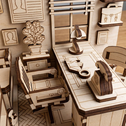 Close-up of laser cut plywood detective office book nook highlighting miniature desk, rotary phone, lamp, and office chair.