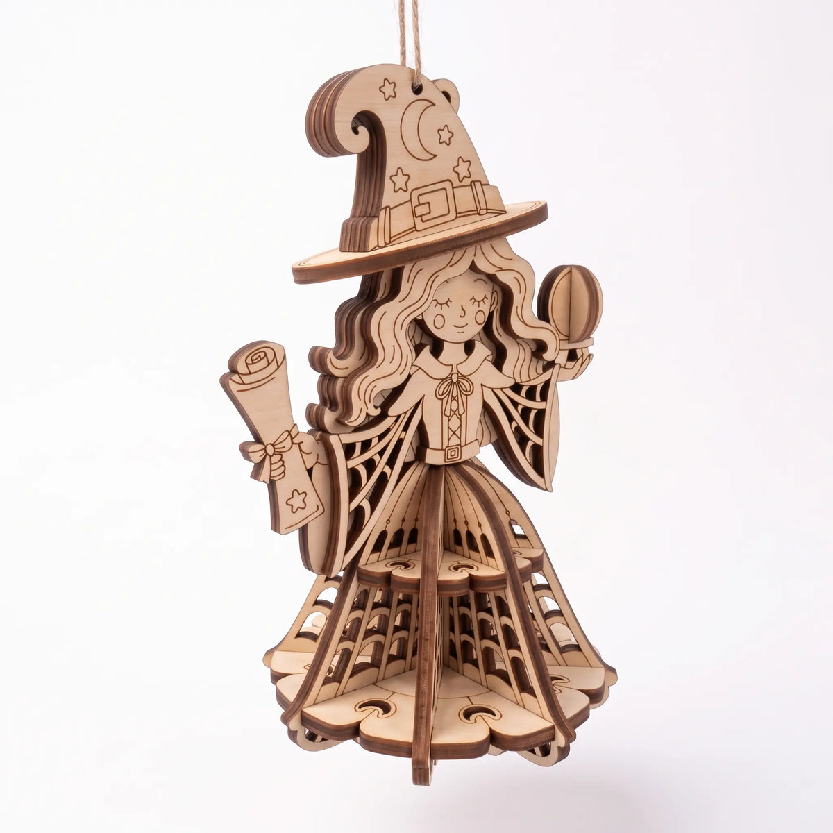 High angle perspective of laser cut plywood Halloween witch figurine with tiered skirt on white base.