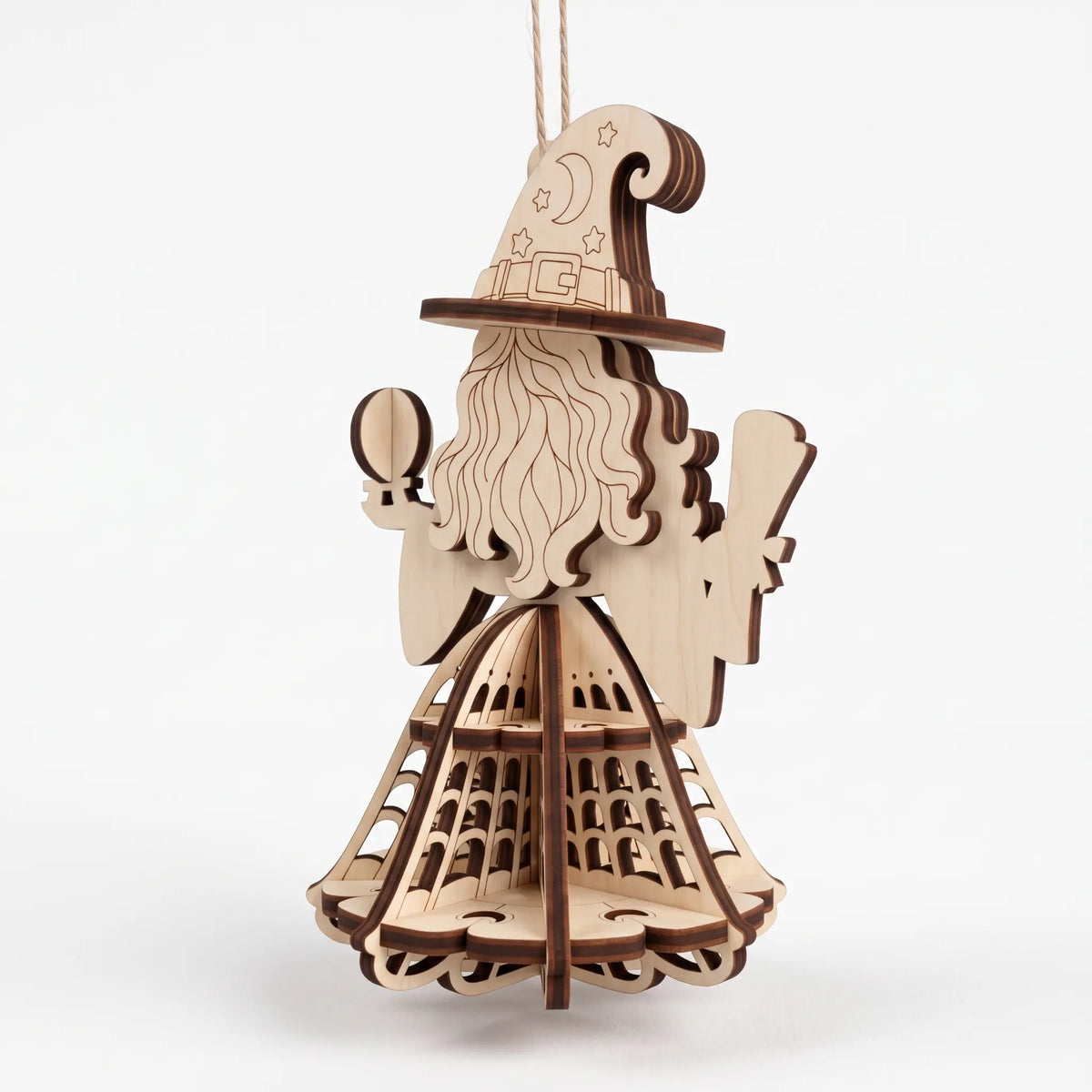 Back angle view of unpainted laser cut plywood witch ornament displaying pointed hat on white ground.