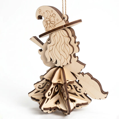 Back angle view of laser cut plywood witch hanging ornament showing wavy hair, broom, and 3D tiered skirt on white backdrop.