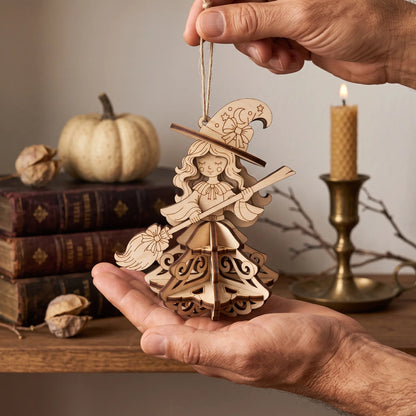 Man holding a 3D laser cut plywood witch ornament in palm, showing scale next to old books, white pumpkin, and candle.