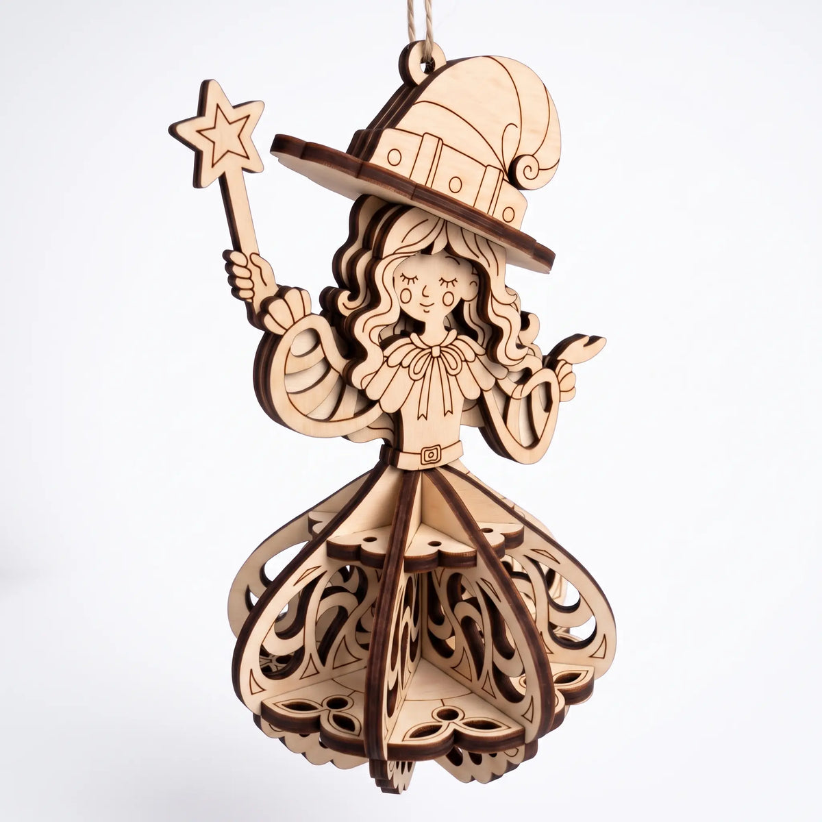 Front view of laser cut plywood witch ornament holding star wand, featuring 3D slotted skirt on plain white background.