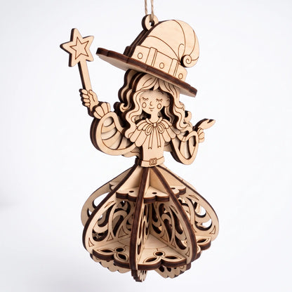 Front view of laser cut plywood witch ornament holding star wand, featuring 3D slotted skirt on plain white background.