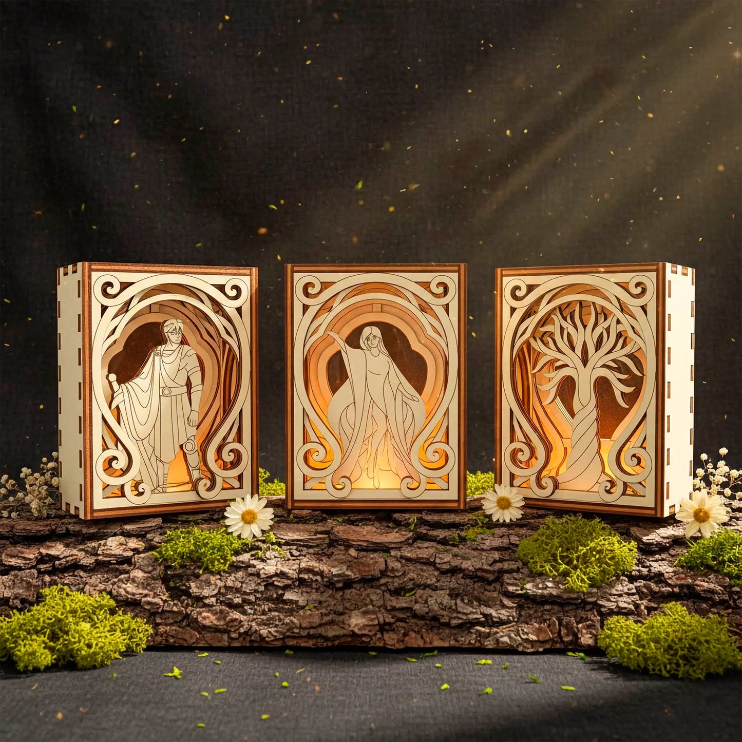 Three wooden laser cut book nooks with engraved designs of a warrior, a woman, and a tree, illuminated against a dark background.