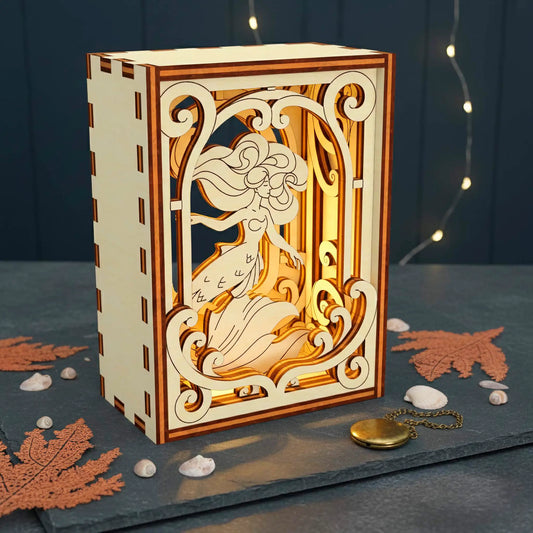 Decorative laser cut book nook with intricate carvings on a dark surface with decorative elements.