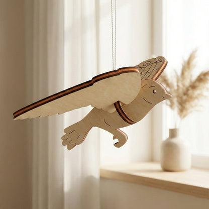 Wooden laser cut  dove ornament hanging in a room with light curtains and a vase.