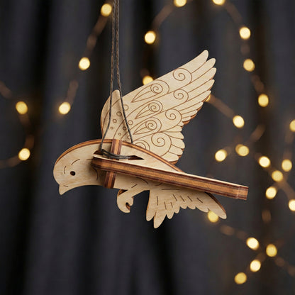 Wooden laser cut bird ornament with intricate details against a blurred light background