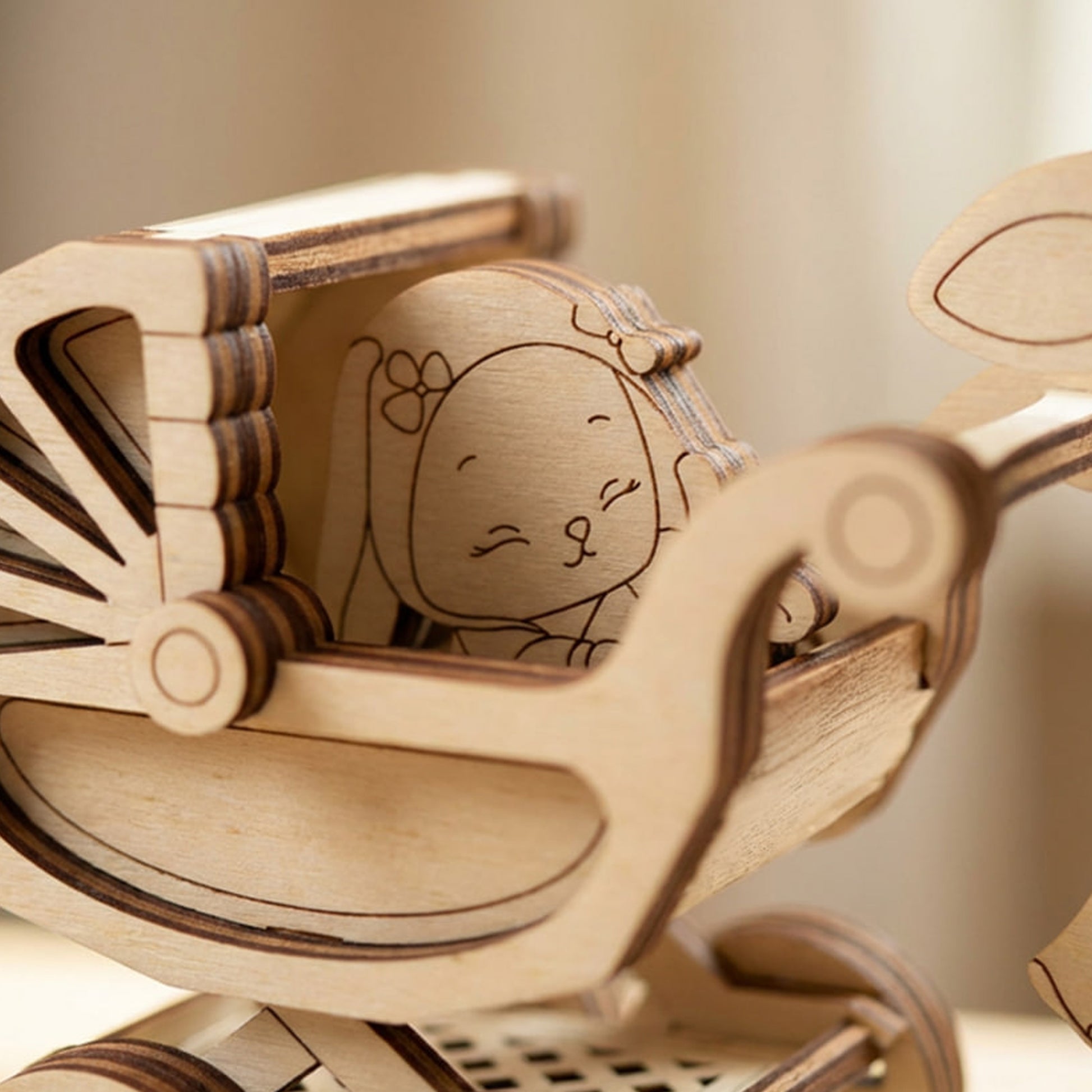 Wooden laser cut toy with a design of a bunny girl with a bow on her head, sitting in a chair.