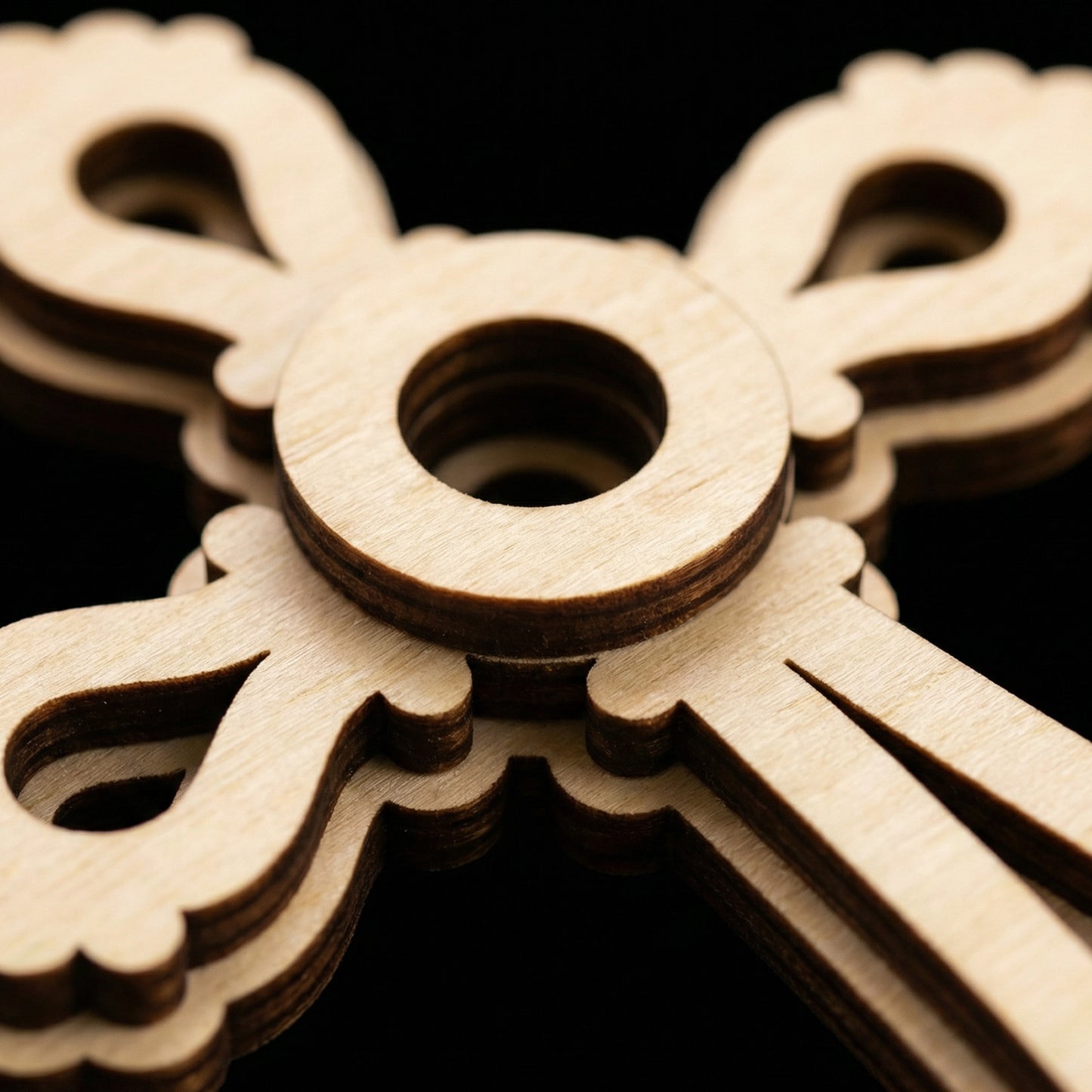 Close-up of a wooden laser cut cross against a dark background