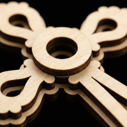 Close-up of a wooden laser cut cross against a dark background