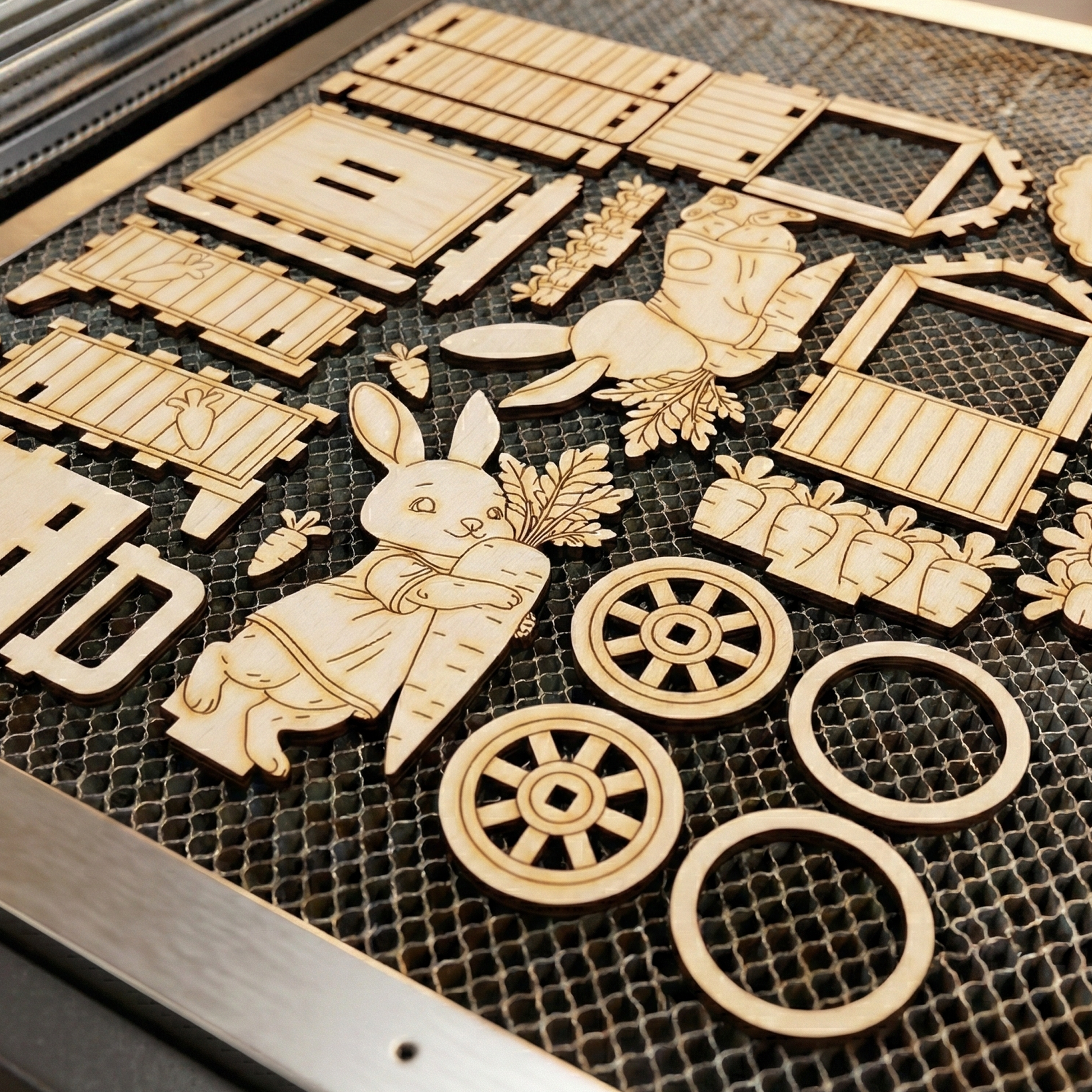 Wooden laser-cut craft pieces on a black grid surface