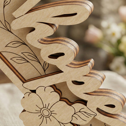 Wooden laser cut word 'hope' with floral patterns on a cross ornament a blurred background
