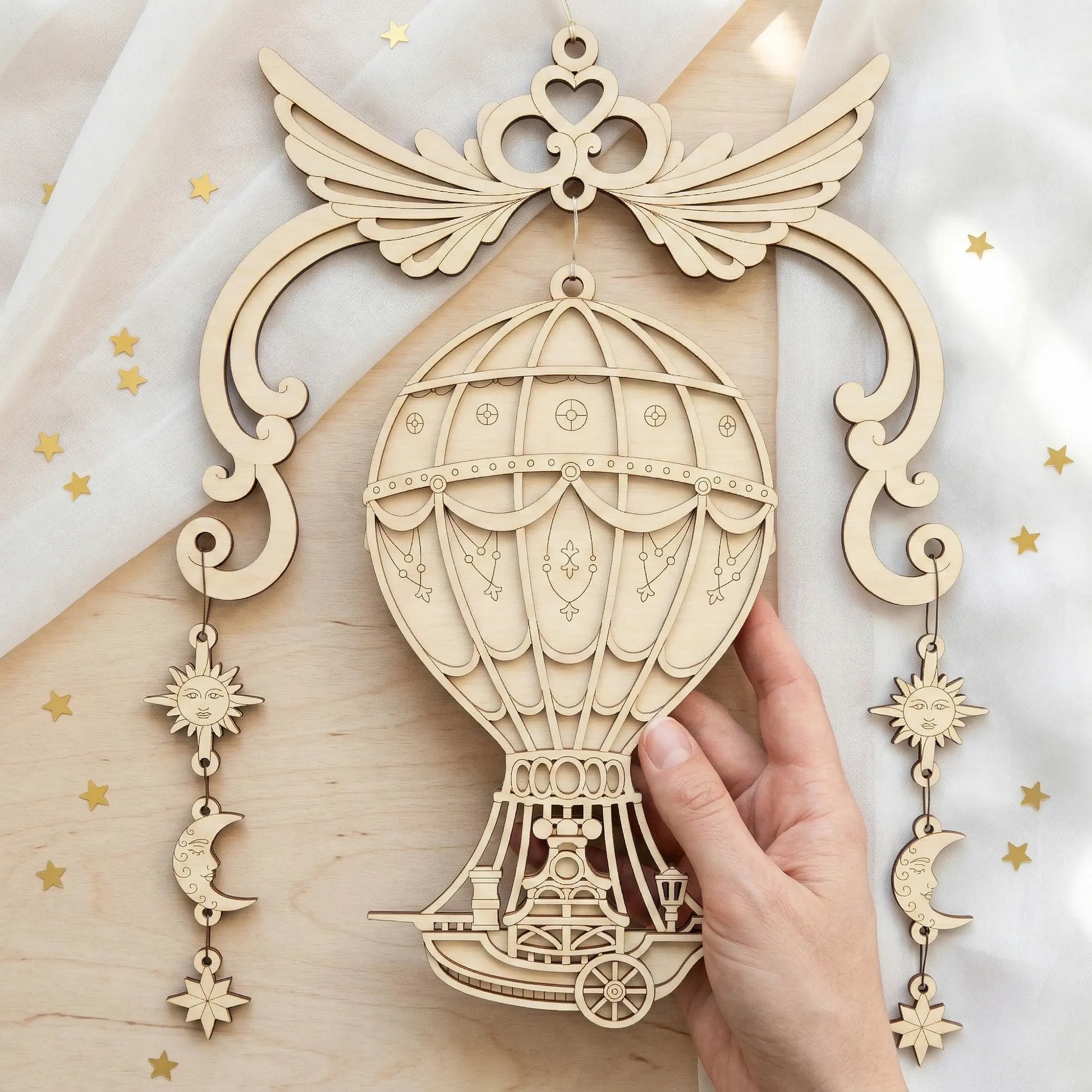 Wooden laser cut steampunk airship wall art with celestial elements on a light background
