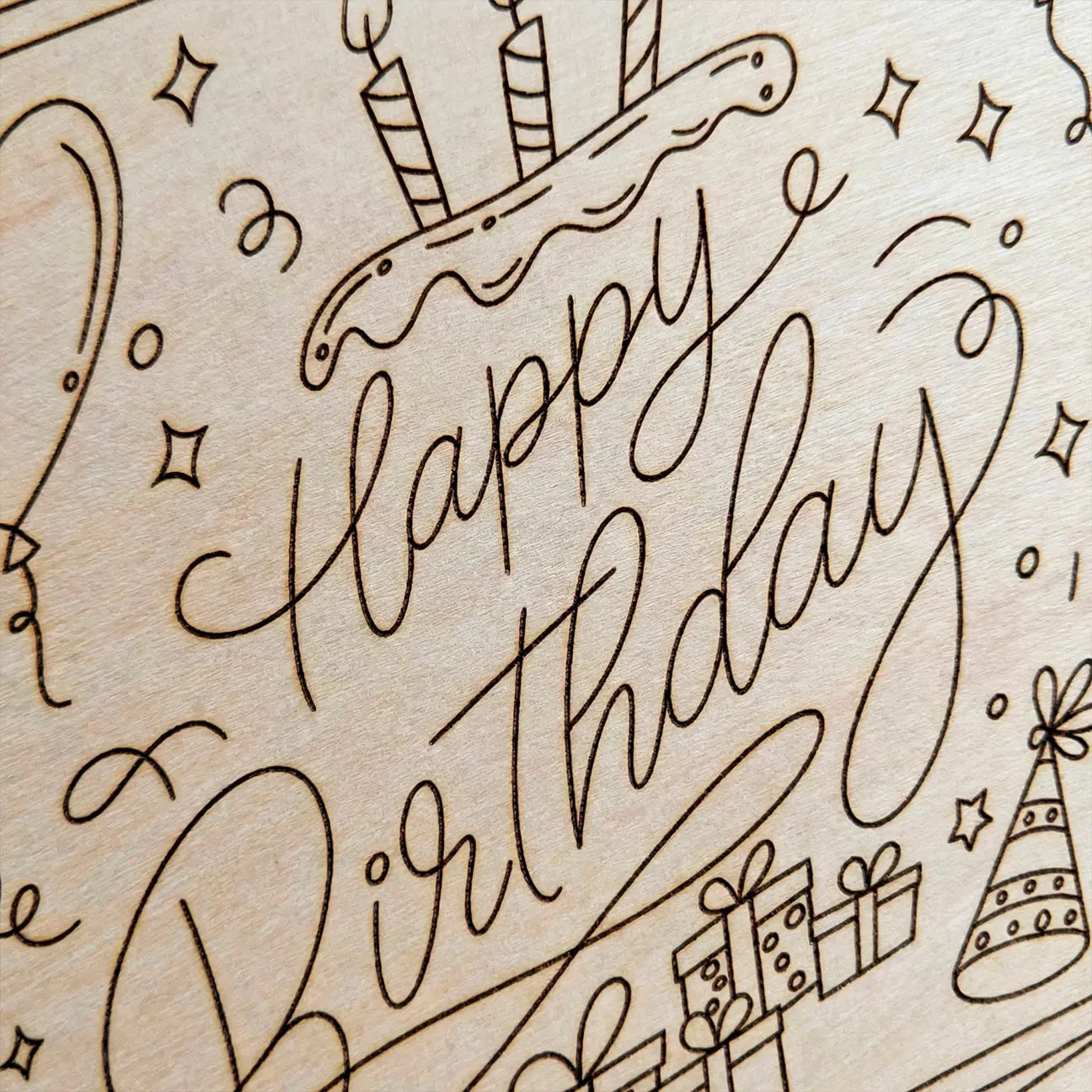 Wooden plaque with 'Happy Birthday' engraving and festive illustrations.