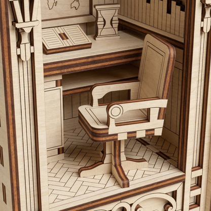 Wooden laser cut model of a room with a desk and chair