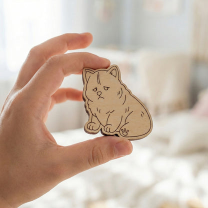 Hand holding a wooden dog-shaped ornament with a blurred background