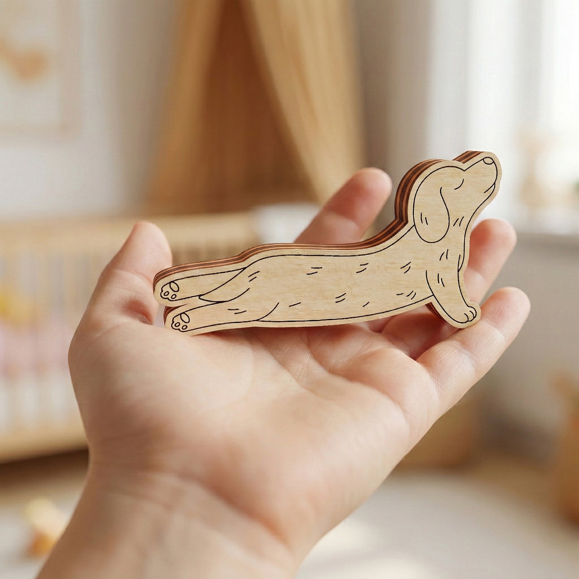 Wooden dog-shaped puzzle held in a hand with a blurred background