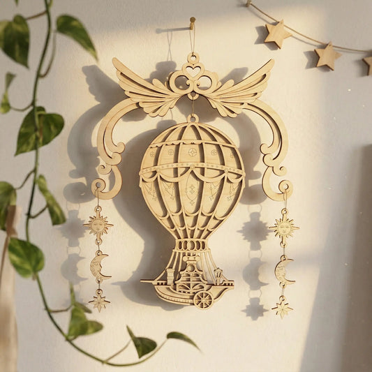 Laser cut hot air balloon ornament with star and moon charms on a light background
