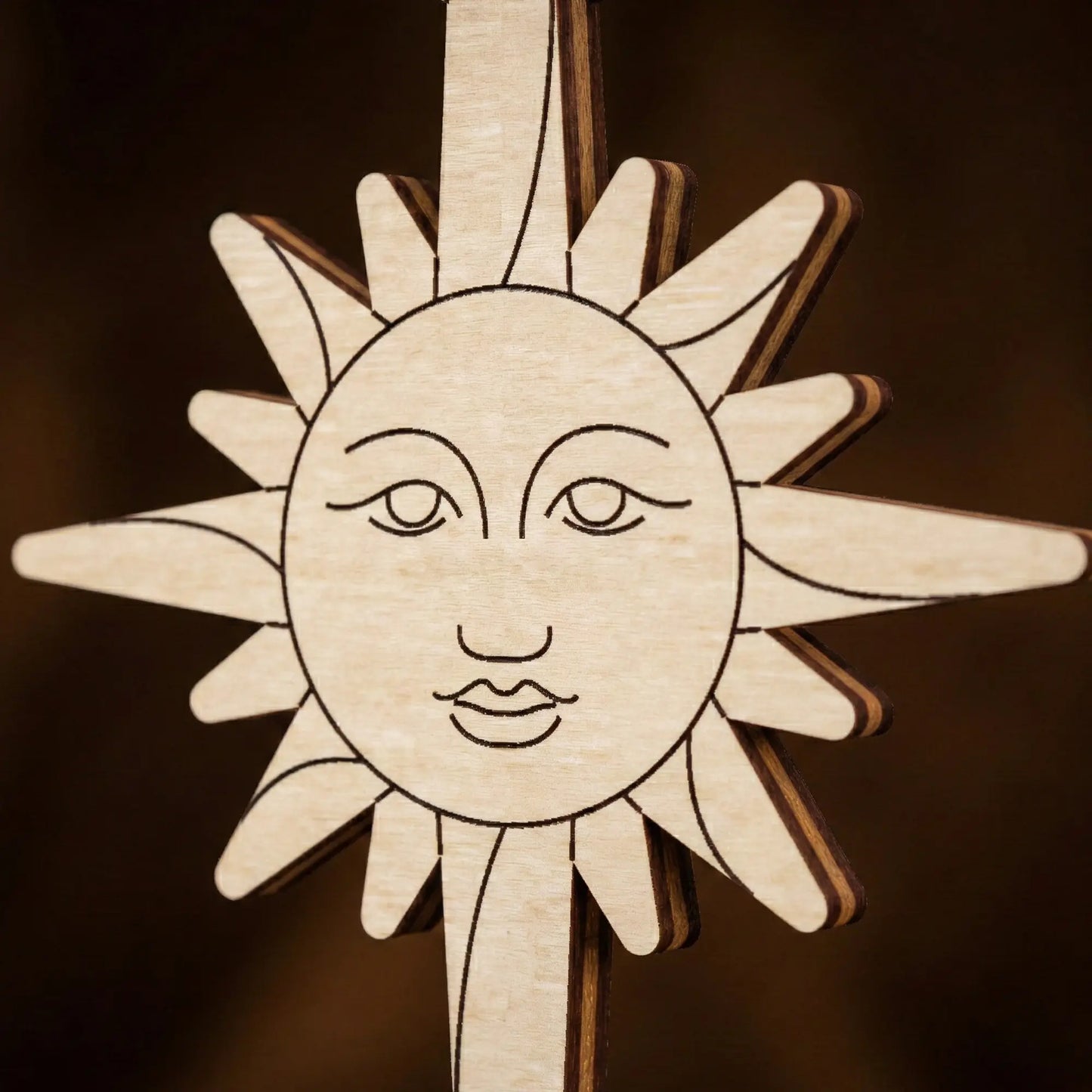 laser cut  sun-shaped ornament with face on a dark background