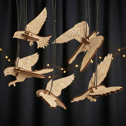 Wooden laser cut  bird ornaments hanging against a dark background with string lights.