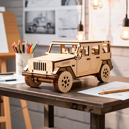 Front three-quarter view of a laser cut wooden plywood SUV model on a desk with pencils and sketches. Showcases intricate interior seating and exterior door handles. The natural wood grain is accented by dark brown laser-engraved lines.