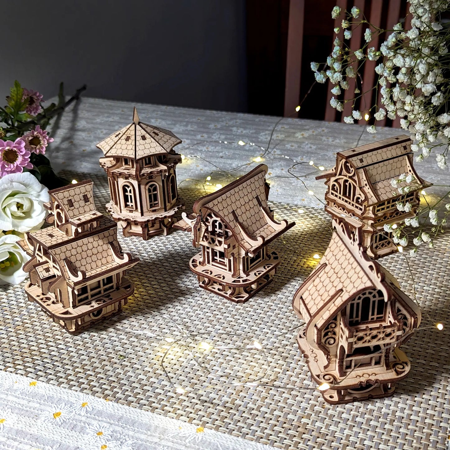 Five unique architectural models made of laser cut plywood set as a tiny town display with delicate baby breath twigs.