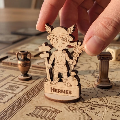 Adult hand placing a laser cut plywood Hermes figurine on a detailed board game map with Greek patterns and game tokens
