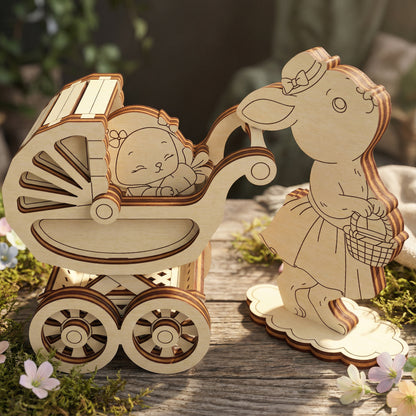 Wooden laser cut baby carriage with a baby figure and a rabbit figure holding a basket on a wooden surface.
