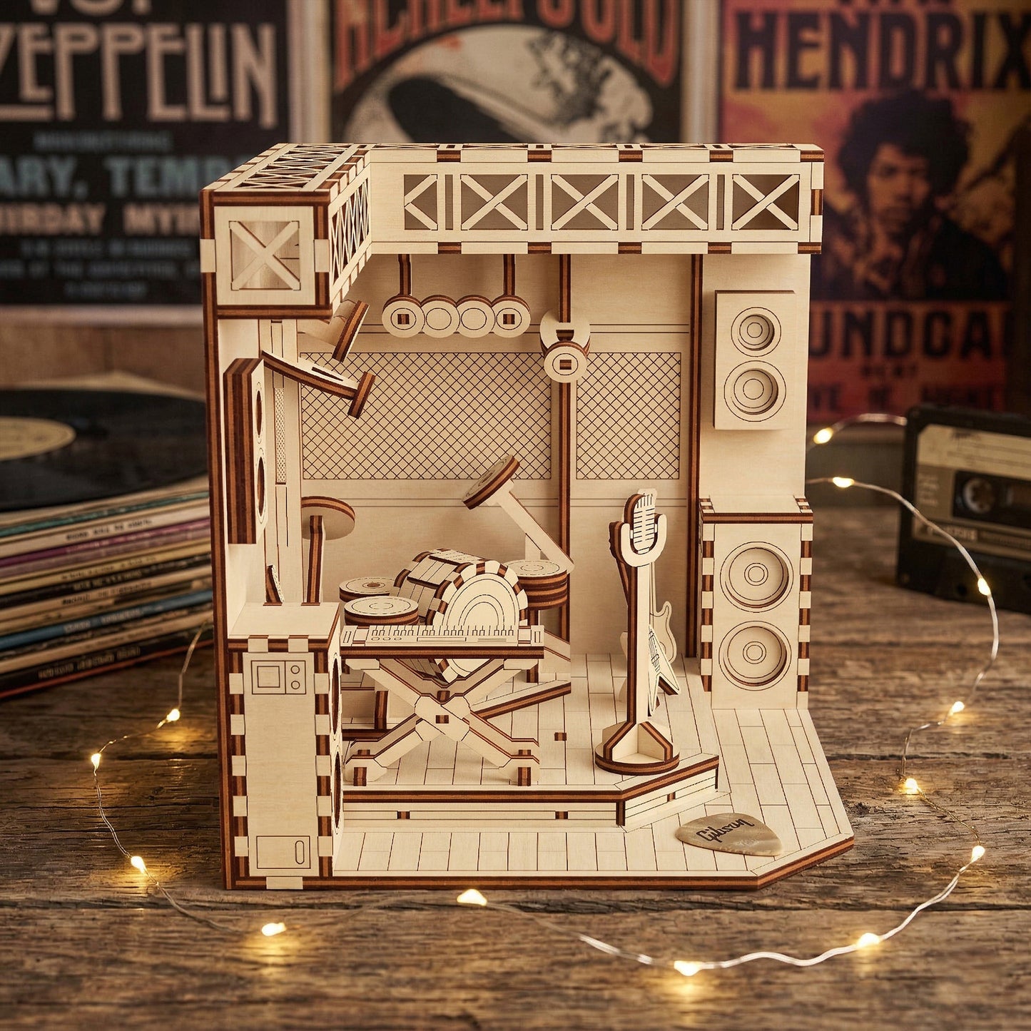 Wooden laser cut model of a music-themed set on a wooden surface with records in the background