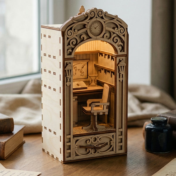 Wooden laser cut book nook model of a miniature room with intricate details on a wooden surface.