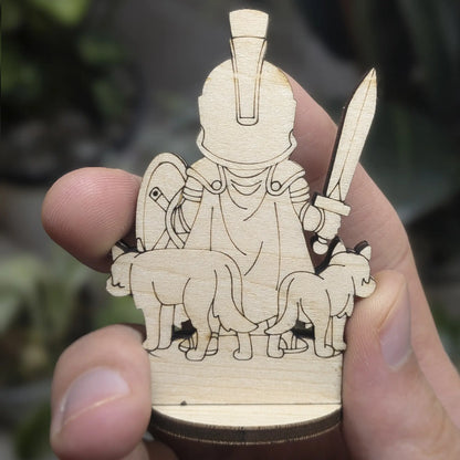Back view of a laser cut plywood Ares held in hand. Shows dark burnt edges, natural wood grain, and detailed cape armor.