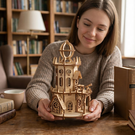 A woman is holding a wooden laser cut plywood model of a castle-like structure, smiling as she looks at it.