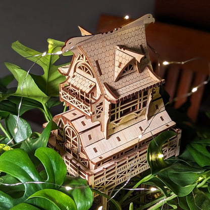 High-angle view of an intricate multi-story fantasy house model crafted from detailed laser cut plywood layers.