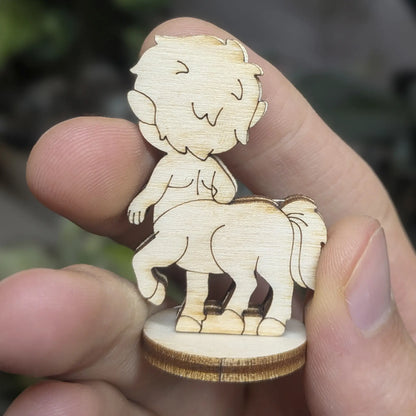 Back view of laser cut plywood centaur held in hand. Highlights the tail texture, dark burnt edges, and natural wood grain
