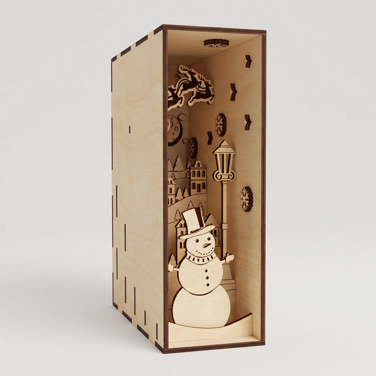 Three-quarter angle view of assembled unlit laser cut plywood Christmas book nook insert on plain white backdrop