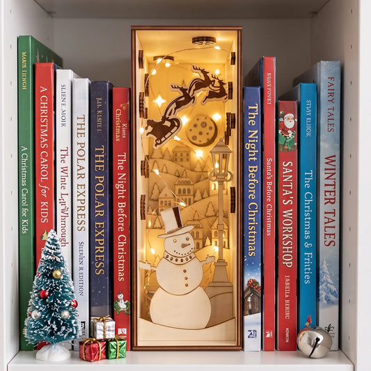 Illuminated laser cut plywood Christmas book nook diorama with snowman and Santa sleigh nestled on bookshelf.