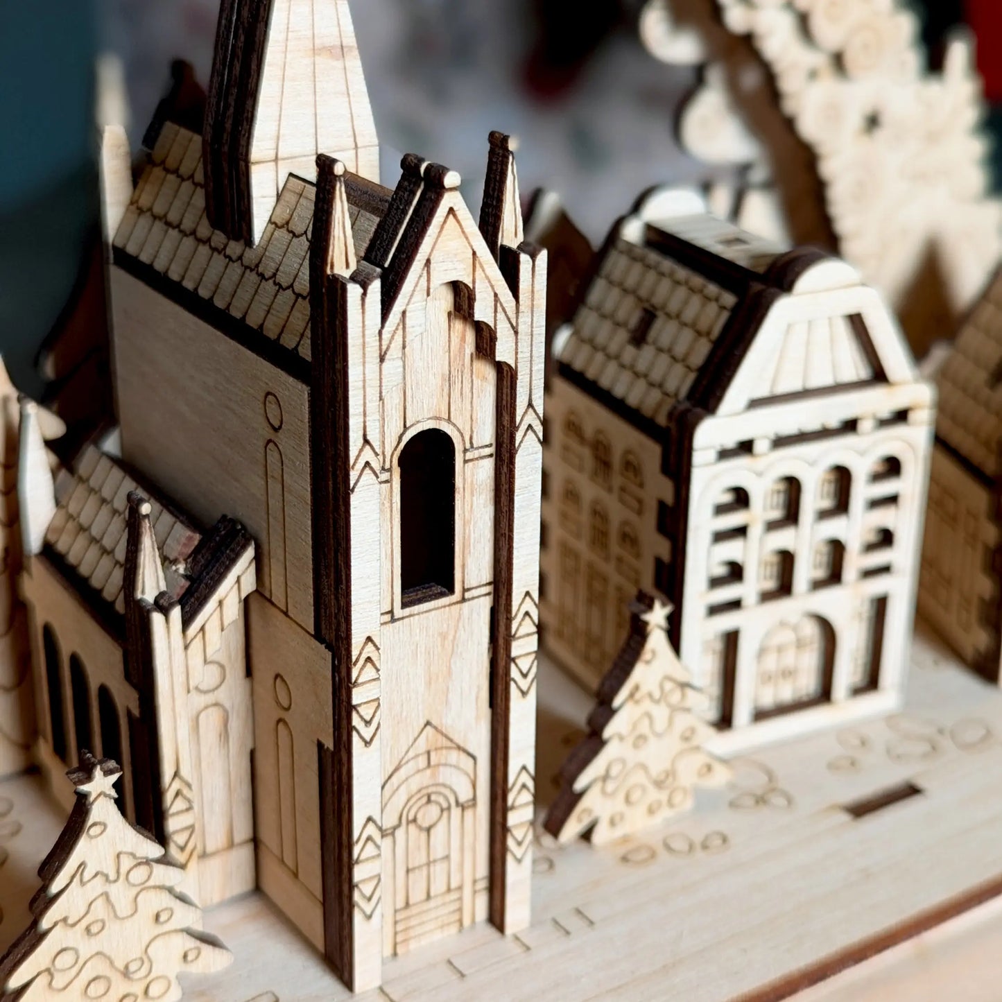 Detailed macro close-up photo focusing on the central miniature Gothic cathedral tower constructed of laser cut plywood
