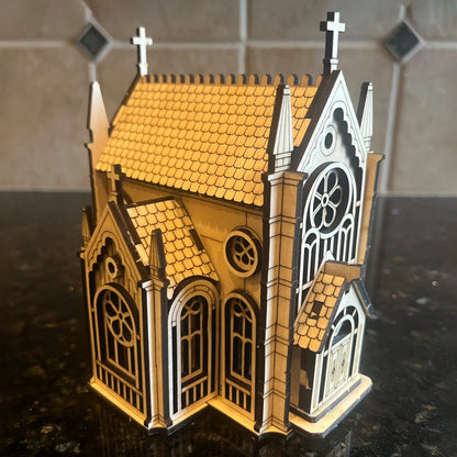 An assembled 3D gothic church miniature model displayed on a dark granite countertop, made from fine laser cut plywood.