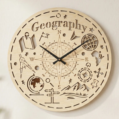 Round laser cut plywood wall clock featuring 'Geography' text, a large compass rose, globe, and mountain icons on white wall