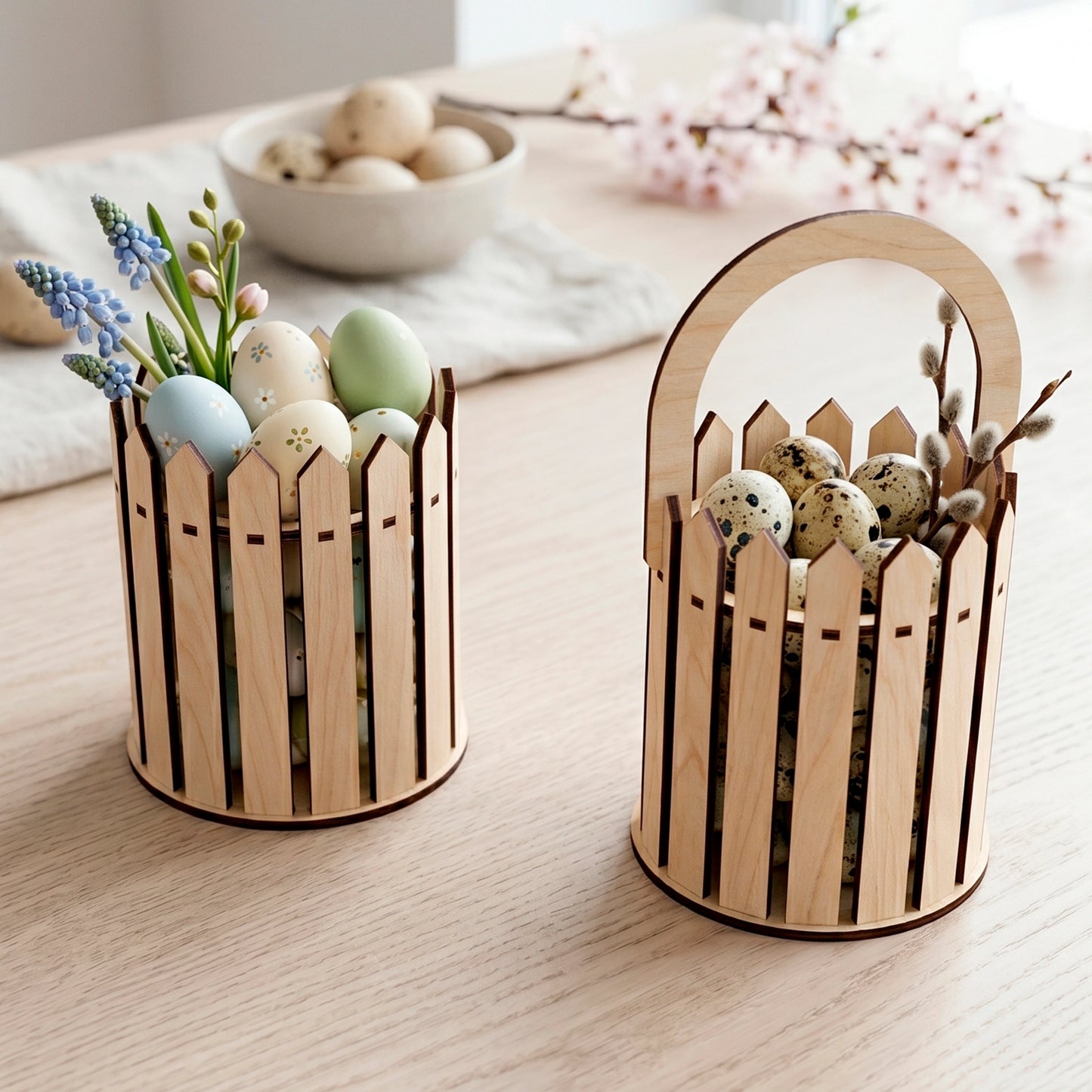 Laser cut plywood Easter basket and picket fence bucket with colorful eggs, pussy willow and muscari on a wooden desk.
