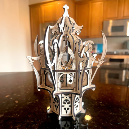 Assembled laser cut plywood elven tower centerpiece standing on a glossy dark kitchen countertop with warm lighting.