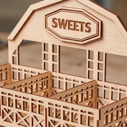Close up of laser cut plywood barn display stand showing engraved Sweets sign, clean wood grain and precise fence details