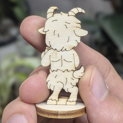 Back view of a laser cut plywood faun held in hand. Shows dark burnt edges, furry texture engravings, and a cute tiny tail.