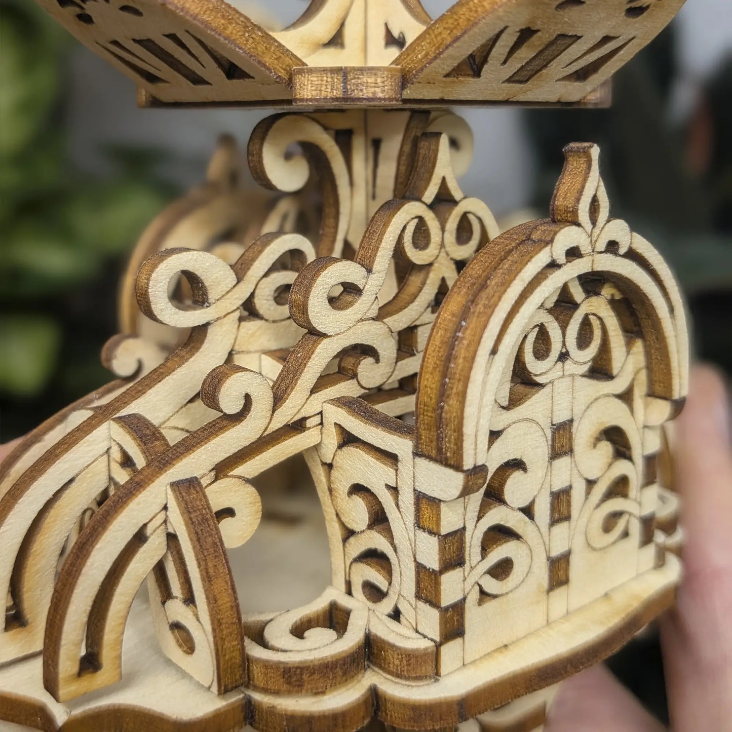 Top view of laser cut plywood fairy house in ferns, showing the interlocking roof petals and ornate scrollwork design work.