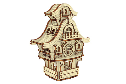 Front-left view of a decorative laser cut plywood easter bunny cottage puzzle on a flat base with detailed carved fences.