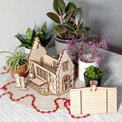 A laser cut plywood garden cottage model with its roof removed and placed alongside to reveal the open internal layouts.